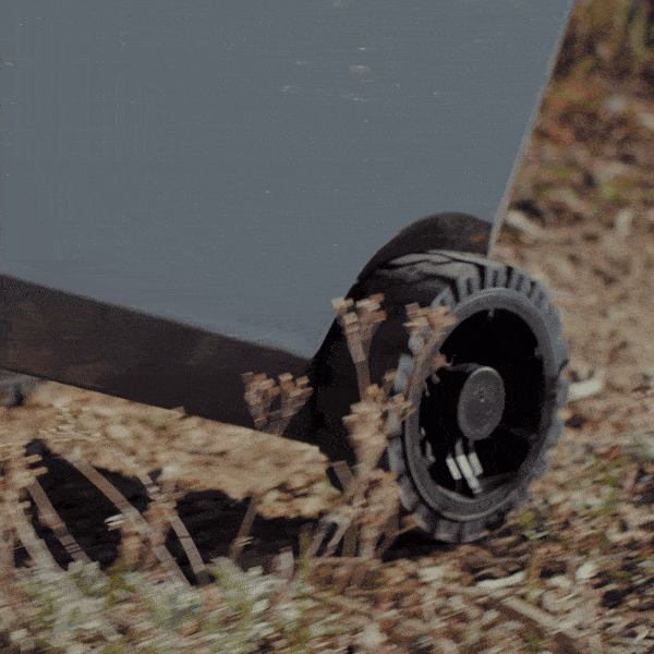 BruTank 55qt Cooler rolling over grass, sand and rocks