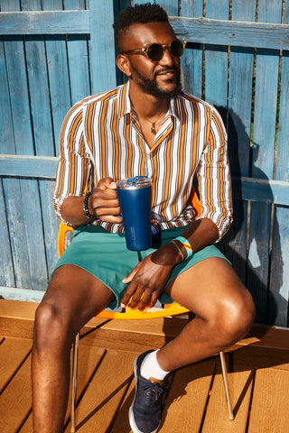 man sitting with coffee tumbler.