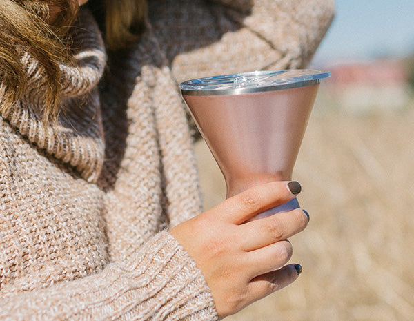 A Woman holding a MargTini outside.