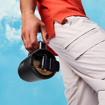 Man holding a Muv 15oz showing the leakproof lid